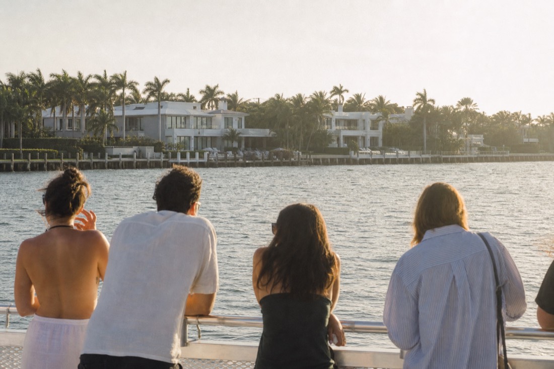 A yacht anchored on calm Biscayne Bay water near Coconut Grove at golden hour, no text, no logos, no people.