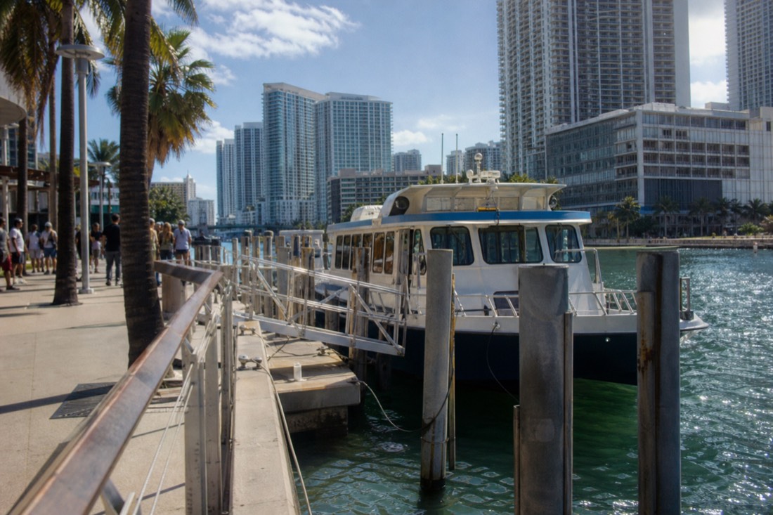 A boat deck at dusk with the illuminated Downtown Miami skyline reflecting on Biscayne Bay, no text, no logos, no people