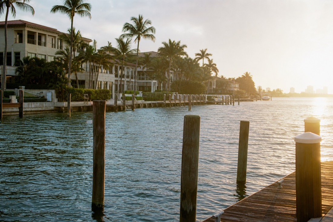 Waterfront mansions along a Miami barrier island seen from the water, no text, no logos, no people.