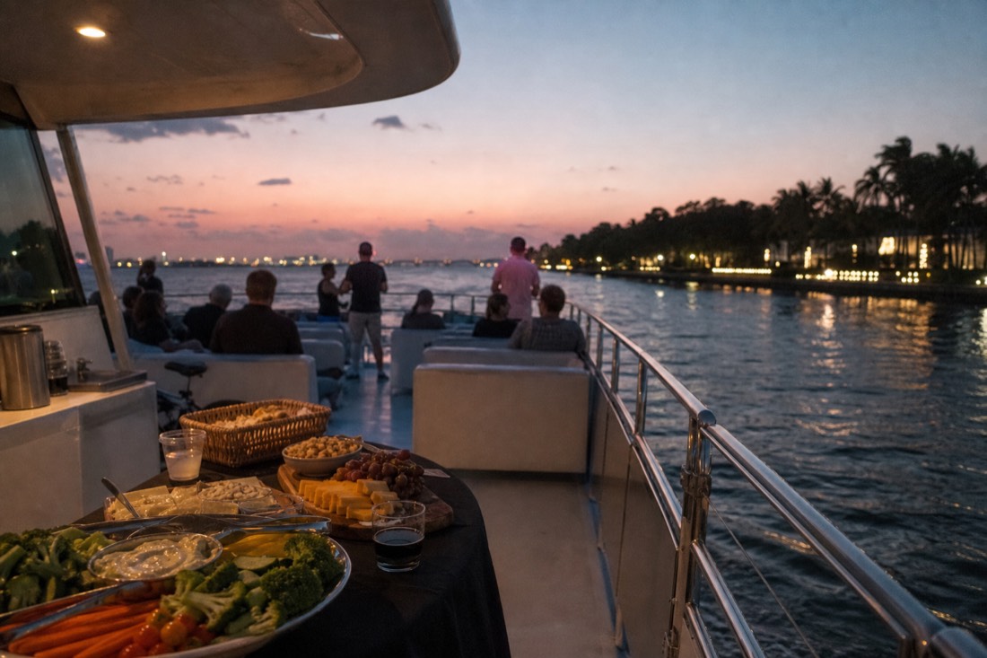 Open-deck sunset cruise boat near the Vizcaya waterfront in Coconut Grove with food and drinks laid out
