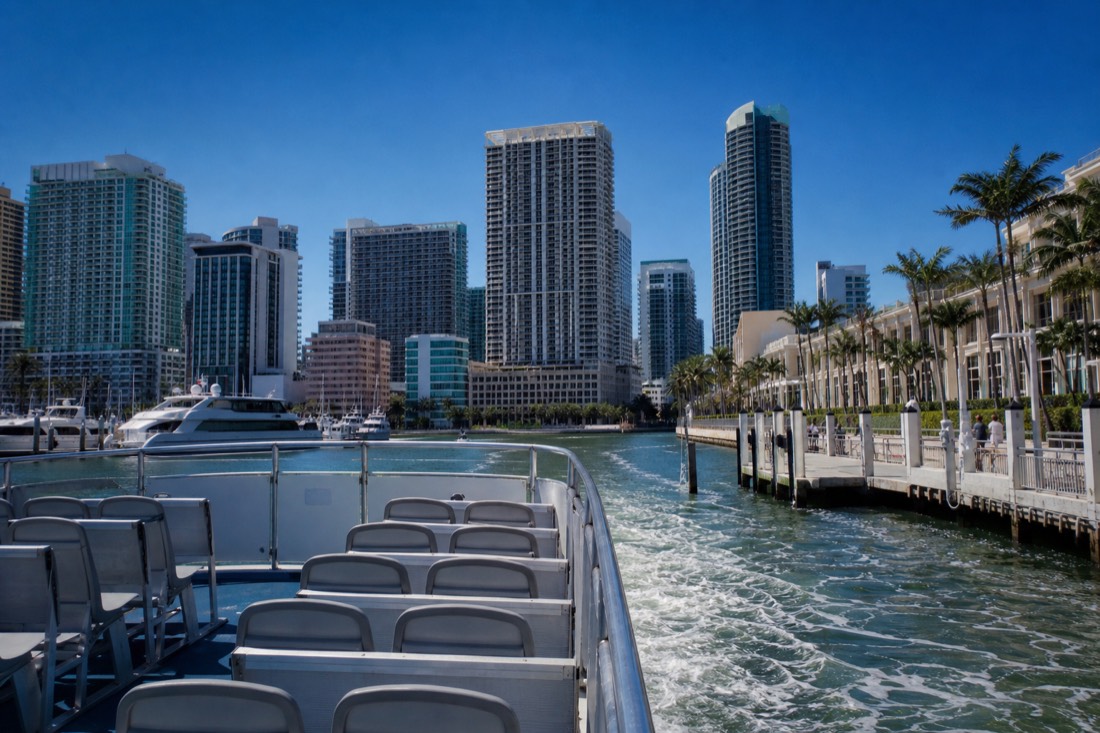 Sightseeing boat departing a downtown Miami marina near Bayside Marketplace with the skyline behind it